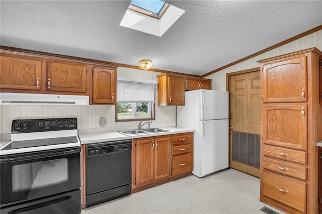 kitchen featuring black appliances, sink, ornamental molding, vaulted ceiling with skylight, and a textured ceiling