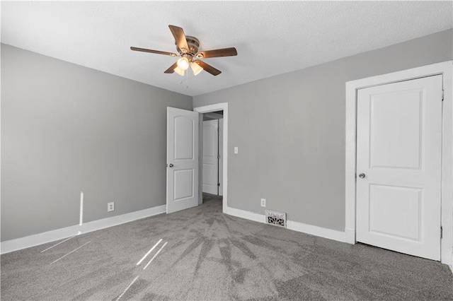 unfurnished bedroom with ceiling fan, carpet, and a textured ceiling