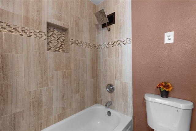 bathroom featuring tiled shower / bath and toilet