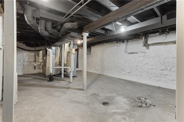 basement featuring water heater and heating unit