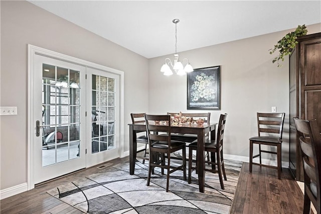 dining room featuring french doors, hardwood / wood-style flooring, and a chandelier