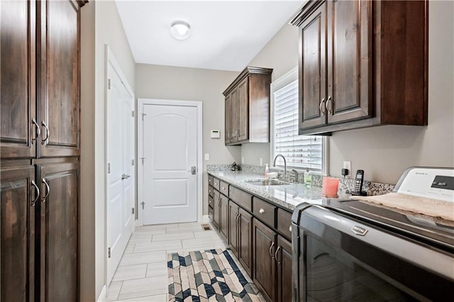 washroom featuring light hardwood / wood-style flooring, sink, washer / clothes dryer, and cabinets