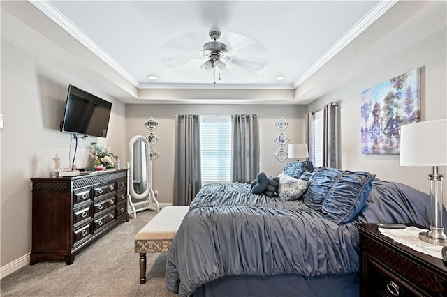 bedroom featuring ceiling fan, a tray ceiling, light carpet, and crown molding