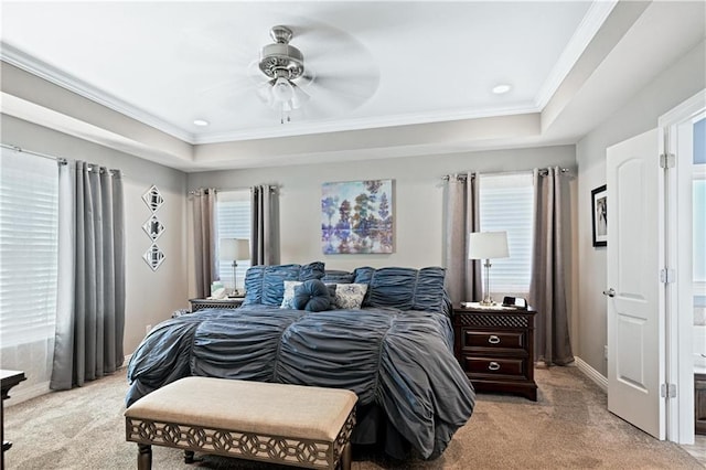 carpeted bedroom featuring ceiling fan, a raised ceiling, and crown molding