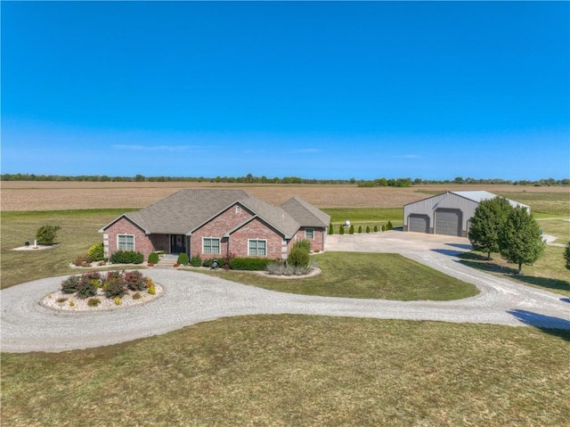 ranch-style house with a rural view, a garage, and a front lawn