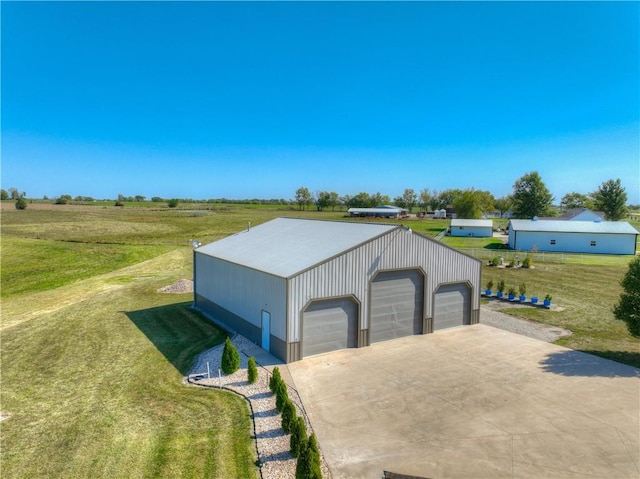 garage featuring a yard and a rural view