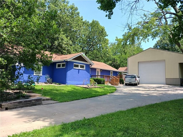 view of front of home featuring a front lawn, a garage, and an outdoor structure