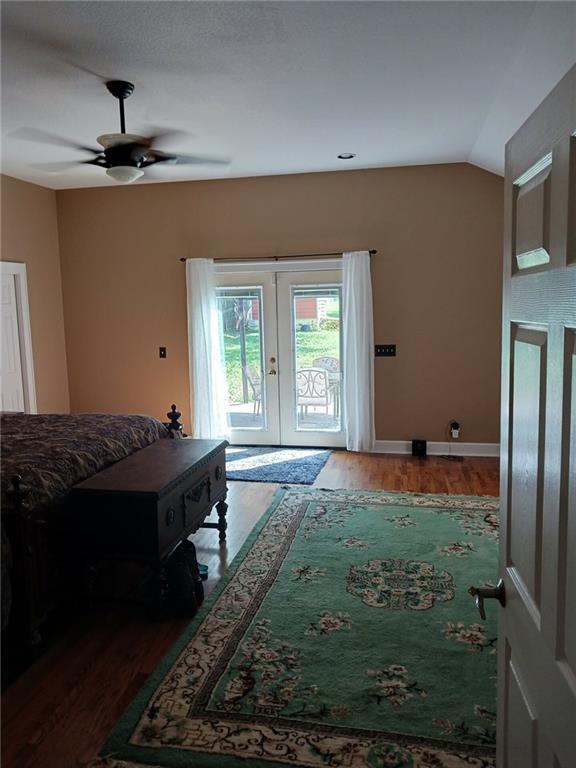 bedroom with access to outside, ceiling fan, lofted ceiling, french doors, and dark hardwood / wood-style flooring