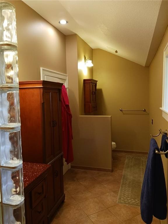 bathroom featuring vaulted ceiling, tile patterned floors, and toilet