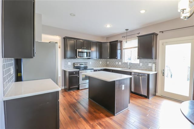 kitchen featuring appliances with stainless steel finishes, sink, a kitchen island, and dark hardwood / wood-style flooring