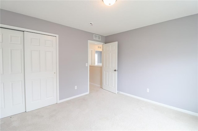 unfurnished bedroom featuring a closet and light carpet