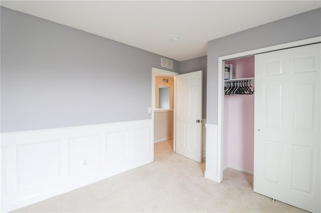 unfurnished bedroom featuring a closet and light colored carpet