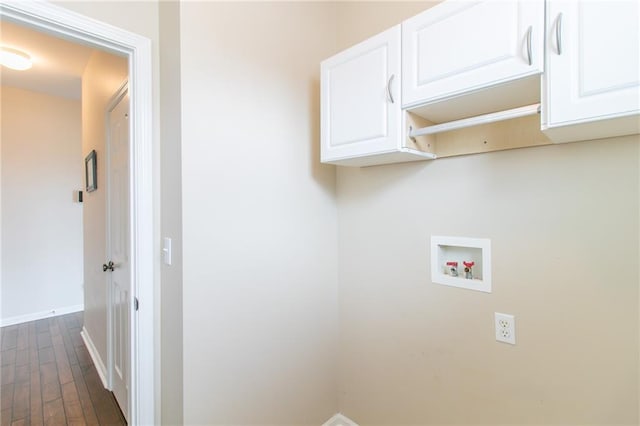 washroom featuring dark wood-type flooring, cabinets, and hookup for a washing machine