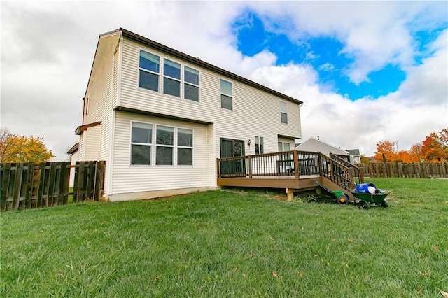 rear view of house with a deck and a lawn