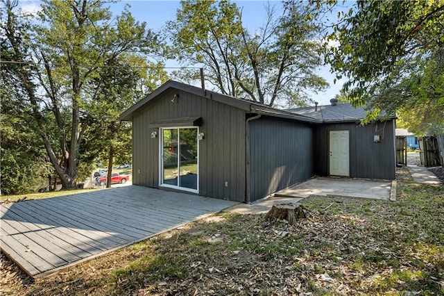 rear view of house with a wooden deck and a patio