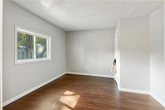 spare room with dark hardwood / wood-style flooring and a textured ceiling