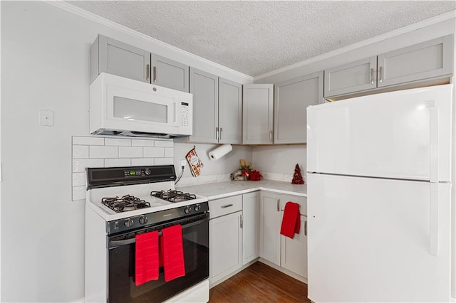 kitchen with ornamental molding, white appliances, gray cabinetry, a textured ceiling, and dark wood-type flooring