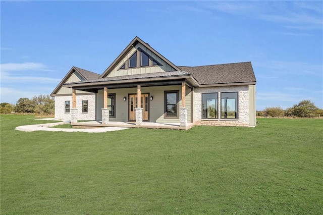 back of house featuring a lawn and a porch