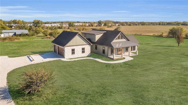 exterior space featuring a yard, a rural view, and a garage