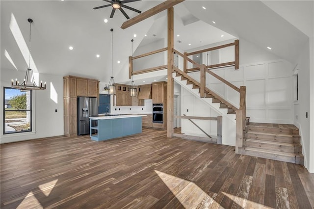 kitchen featuring appliances with stainless steel finishes, a large island, hanging light fixtures, and high vaulted ceiling