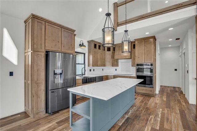 kitchen featuring a center island, stainless steel appliances, light stone counters, dark hardwood / wood-style flooring, and pendant lighting