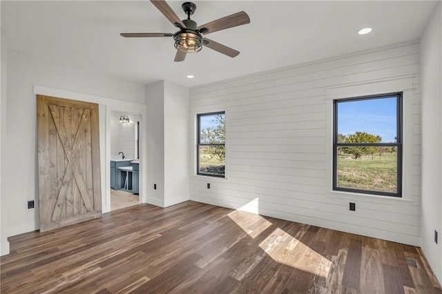 unfurnished living room featuring ceiling fan, dark hardwood / wood-style flooring, and a wealth of natural light