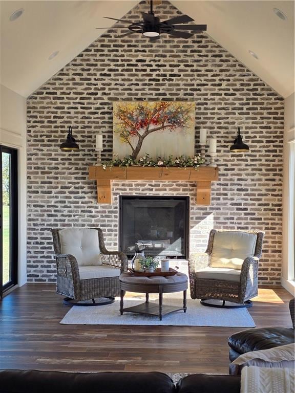 living room featuring hardwood / wood-style floors, ceiling fan, brick wall, and high vaulted ceiling