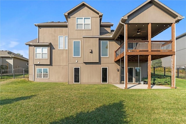 rear view of house with a patio, a wooden deck, a lawn, and ceiling fan