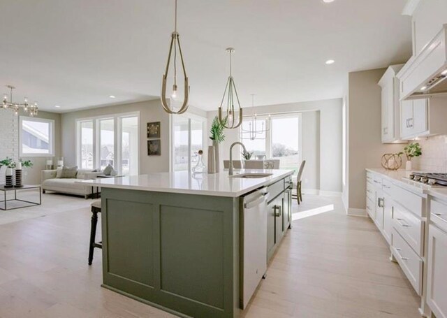 9300 Zarda Dr, Lenexa, KS 66227 - kitchen with a chandelier, dishwashing machine, white cabinetry, and a sink