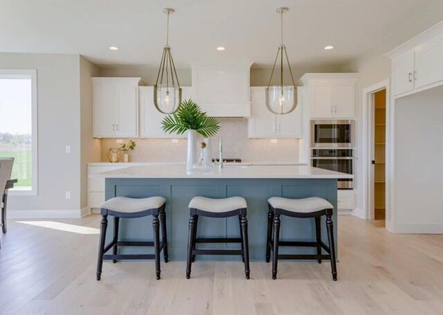 9300 Zarda Dr, Lenexa, KS 66227 - kitchen with white cabinetry, tasteful backsplash, light wood-style floors, and light countertops