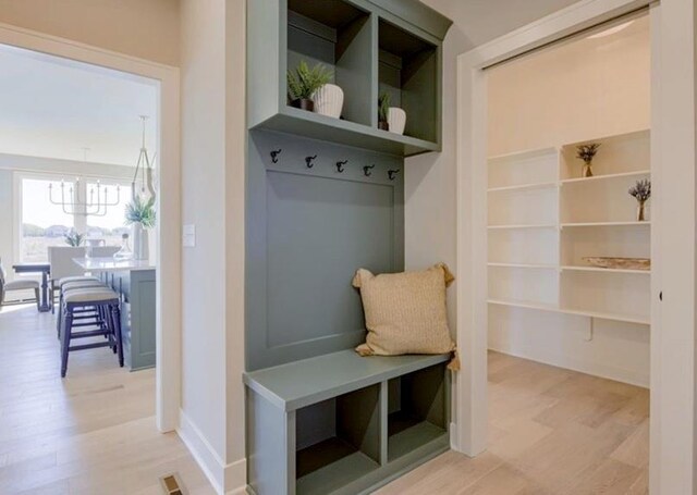 9300 Zarda Dr, Lenexa, KS 66227 - mudroom featuring a chandelier, light wood-style flooring, and baseboards