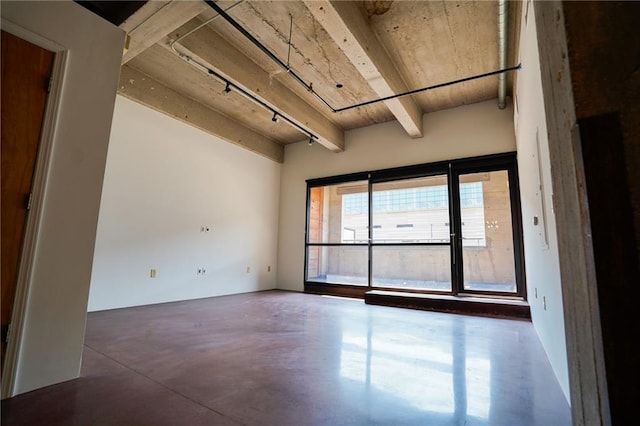 unfurnished room featuring beamed ceiling