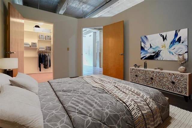 bedroom featuring wooden ceiling, a walk in closet, beamed ceiling, and a closet