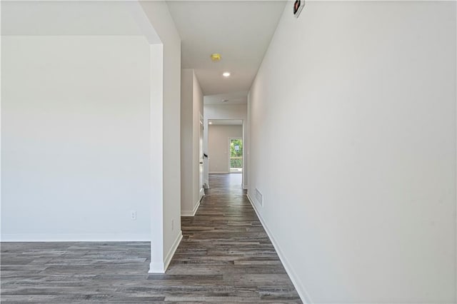 corridor with dark hardwood / wood-style flooring