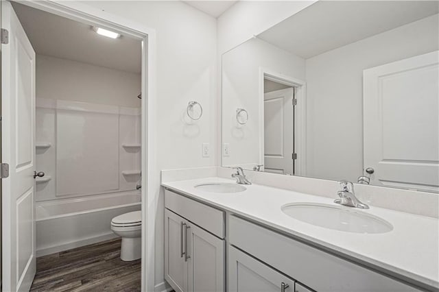 full bathroom with wood-type flooring, shower / bathtub combination, vanity, and toilet