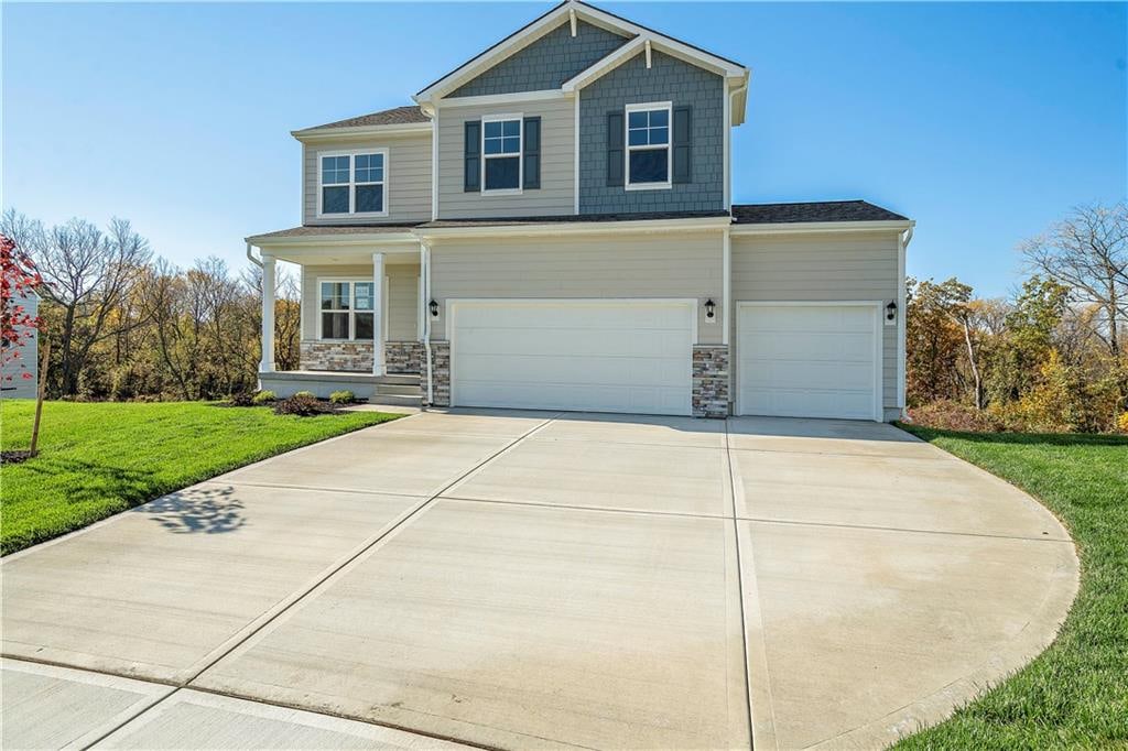 view of front of house featuring a porch, a front lawn, and a garage