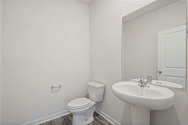 bathroom with hardwood / wood-style flooring and toilet