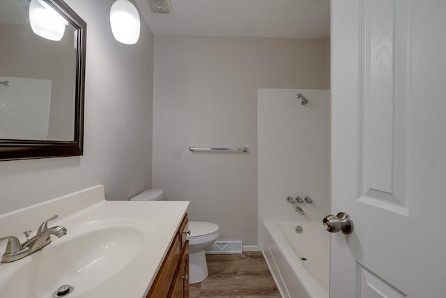 full bathroom with vanity, toilet, tiled shower / bath combo, and hardwood / wood-style floors