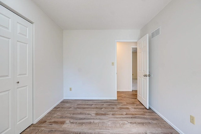 unfurnished bedroom with light hardwood / wood-style floors and a closet