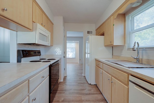 kitchen with light brown cabinetry, sink, light hardwood / wood-style flooring, white appliances, and decorative backsplash