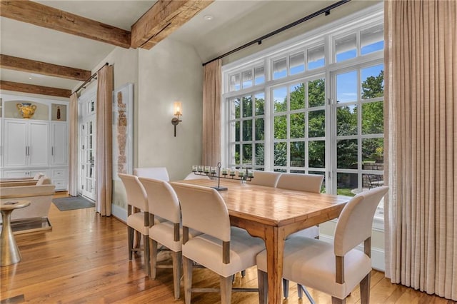 dining space with beam ceiling and light wood-type flooring