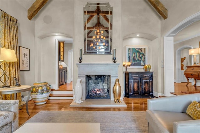 living room featuring hardwood / wood-style flooring, beamed ceiling, and high vaulted ceiling