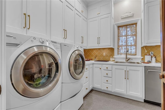 clothes washing area with sink, light tile patterned flooring, washing machine and clothes dryer, and cabinets