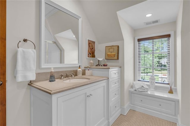 bathroom featuring vanity, tile patterned floors, and vaulted ceiling