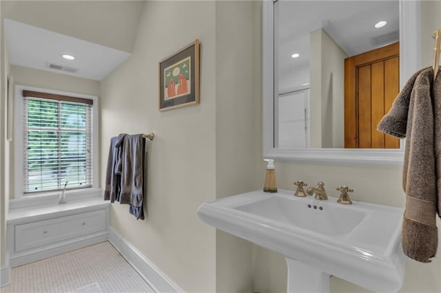 bathroom with tile patterned floors, sink, and vaulted ceiling