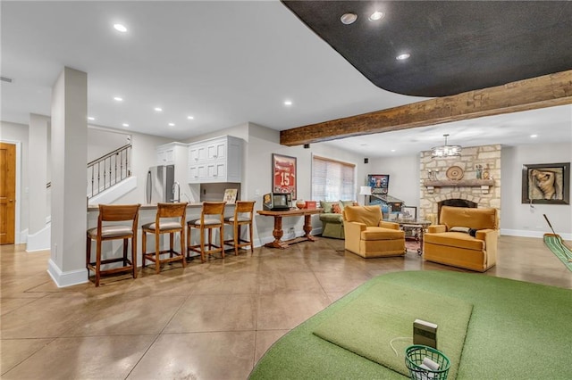 rec room featuring beam ceiling and a fireplace