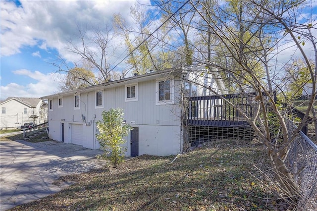 rear view of house with a garage and a wooden deck