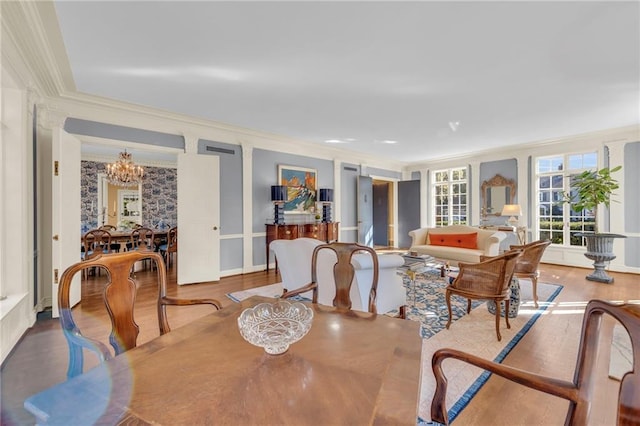 dining room with an inviting chandelier, ornamental molding, and hardwood / wood-style flooring