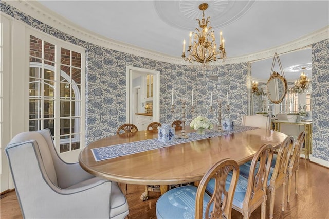 dining space with crown molding, a chandelier, and wood-type flooring