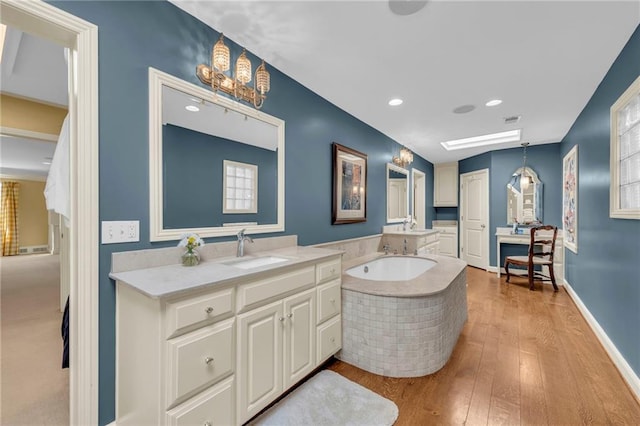 bathroom featuring vanity, a tub, hardwood / wood-style flooring, and plenty of natural light